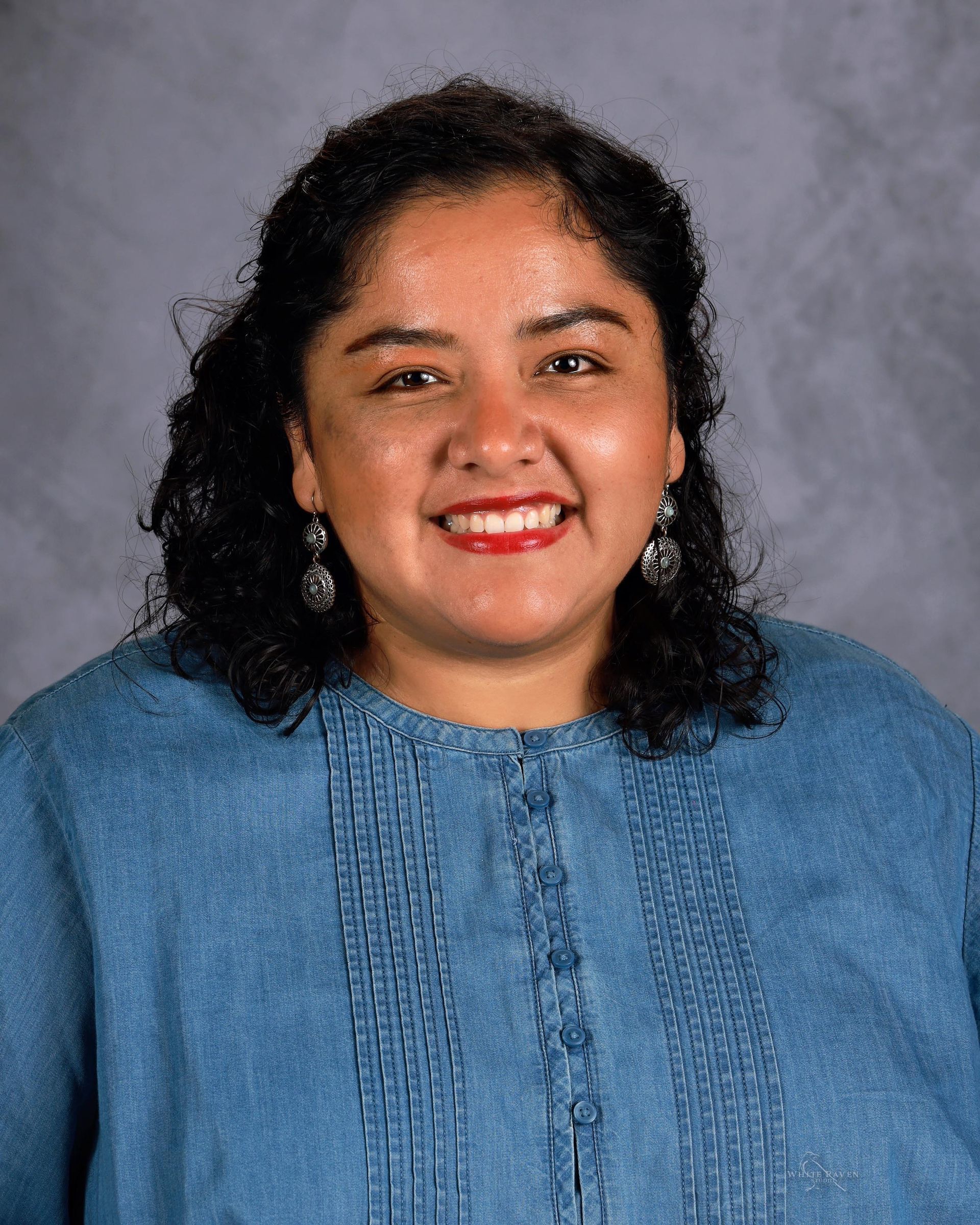 Woman smiling in front of gray backdrop