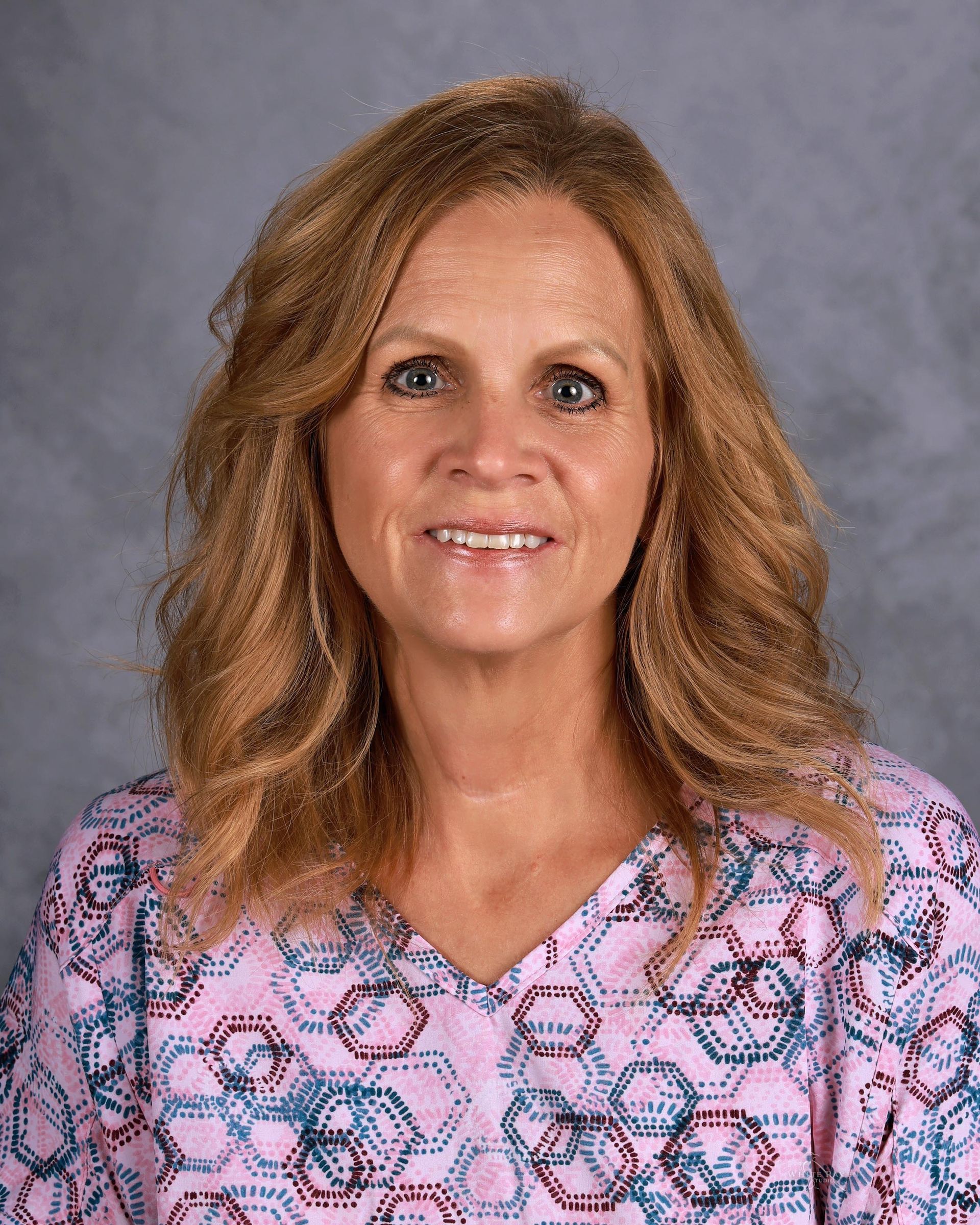 Woman smiling in front of gray backdrop