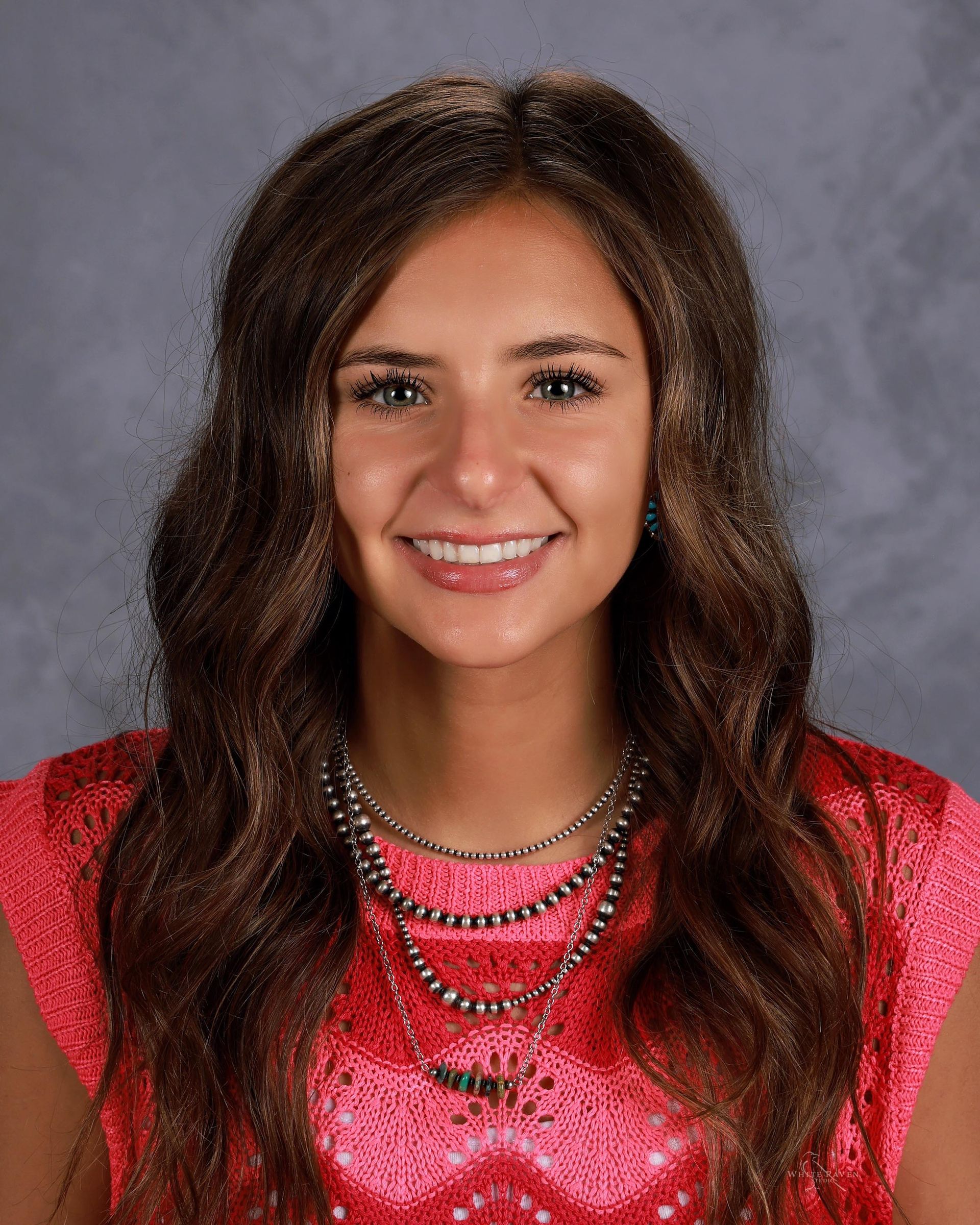 Woman smiling in front of gray backdrop