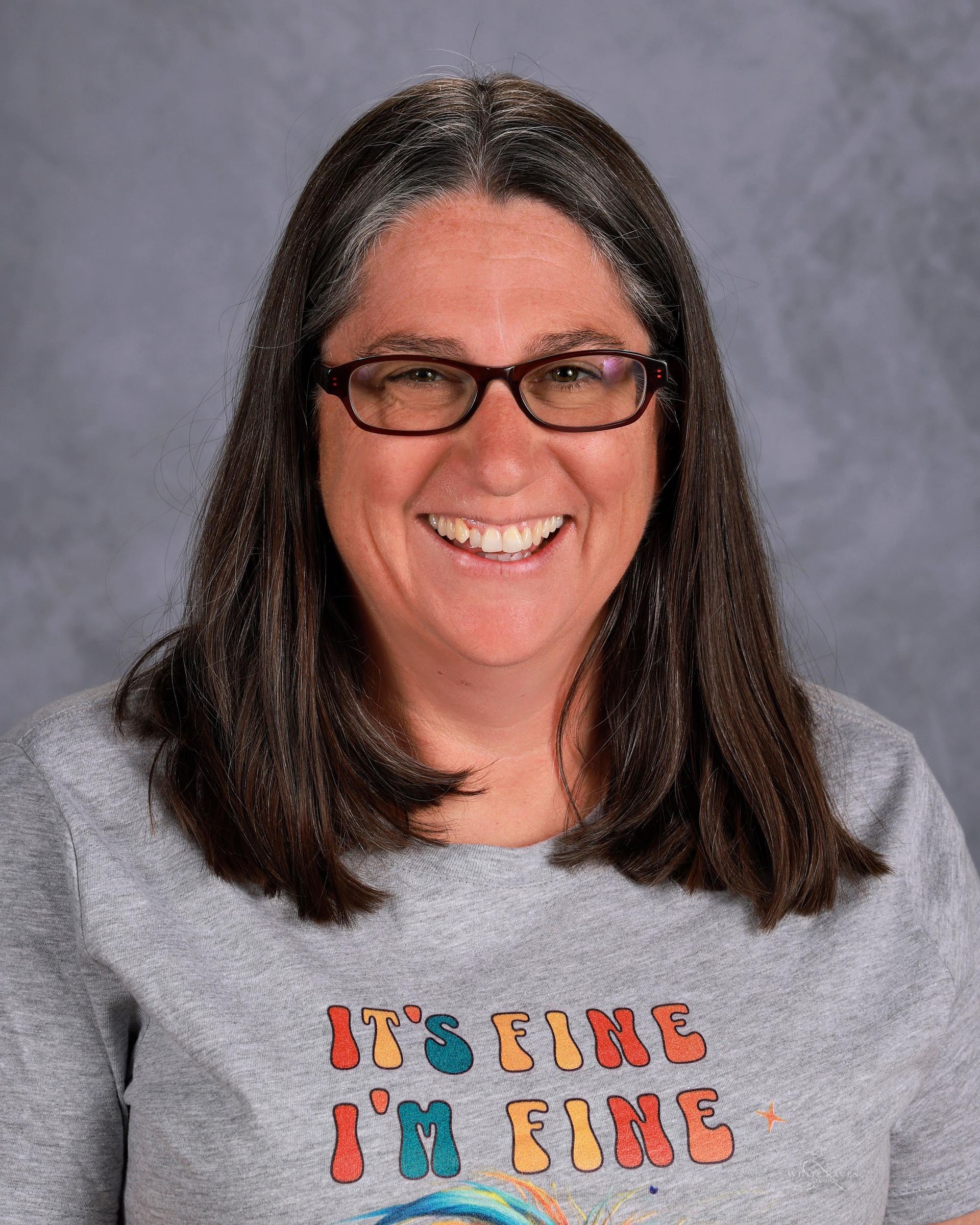 Woman smiling in front of gray backdrop