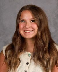 Woman smiling in front of gray backdrop