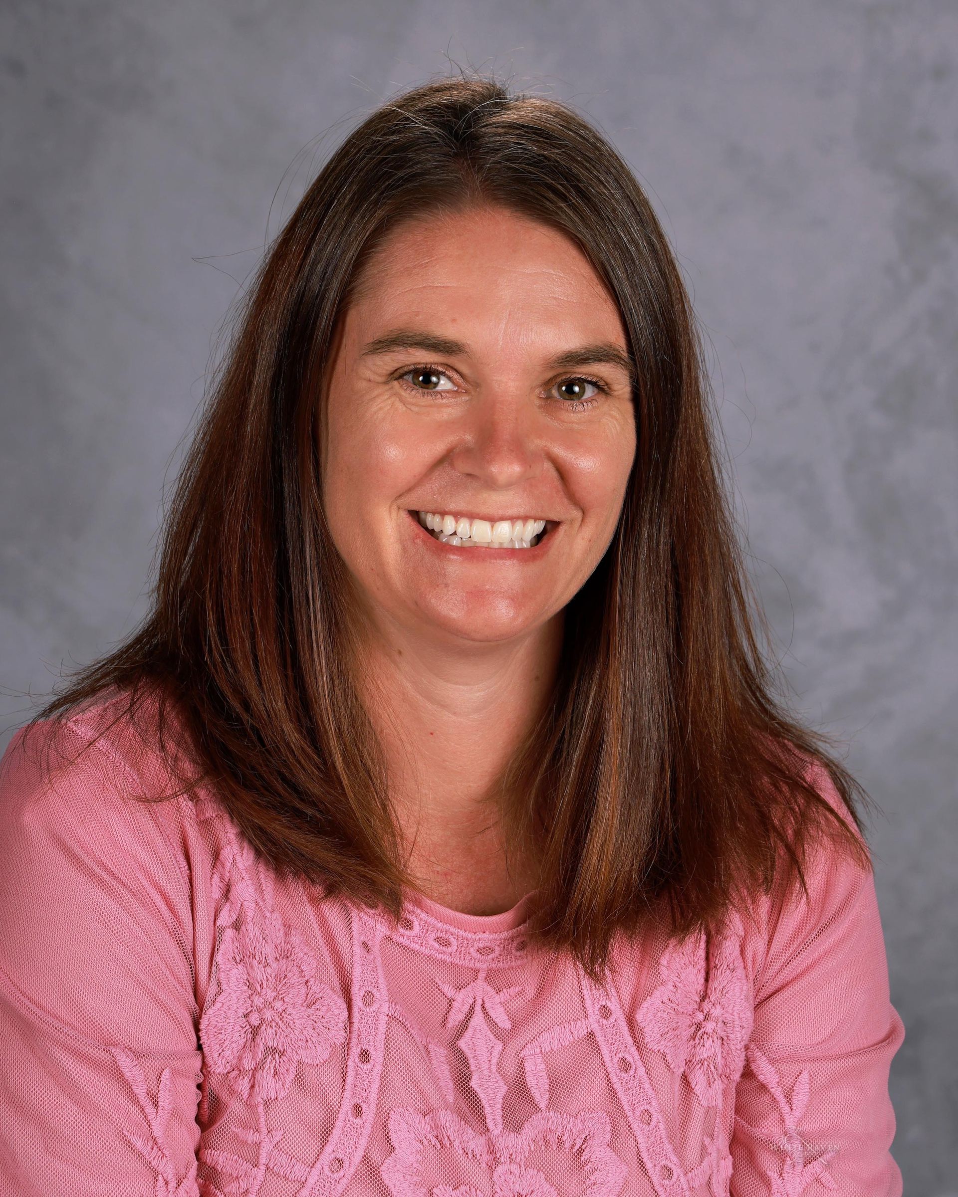 Woman smiling in front of gray backdrop