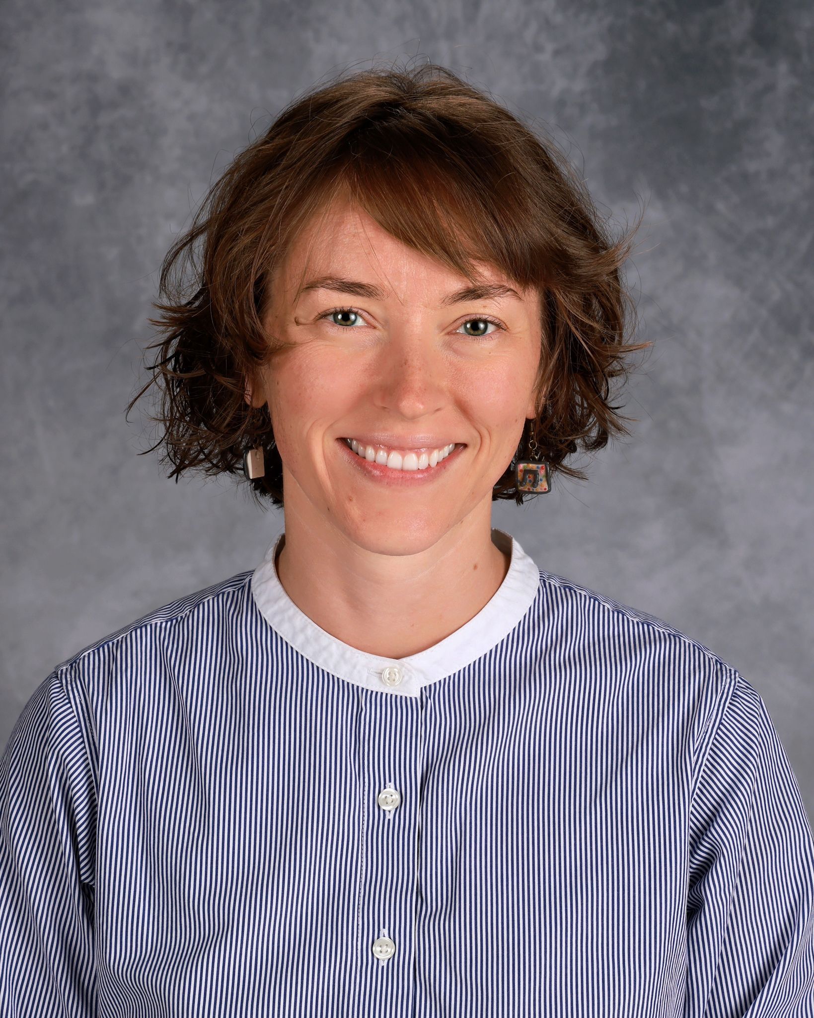Woman smiling in front of gray backdrop