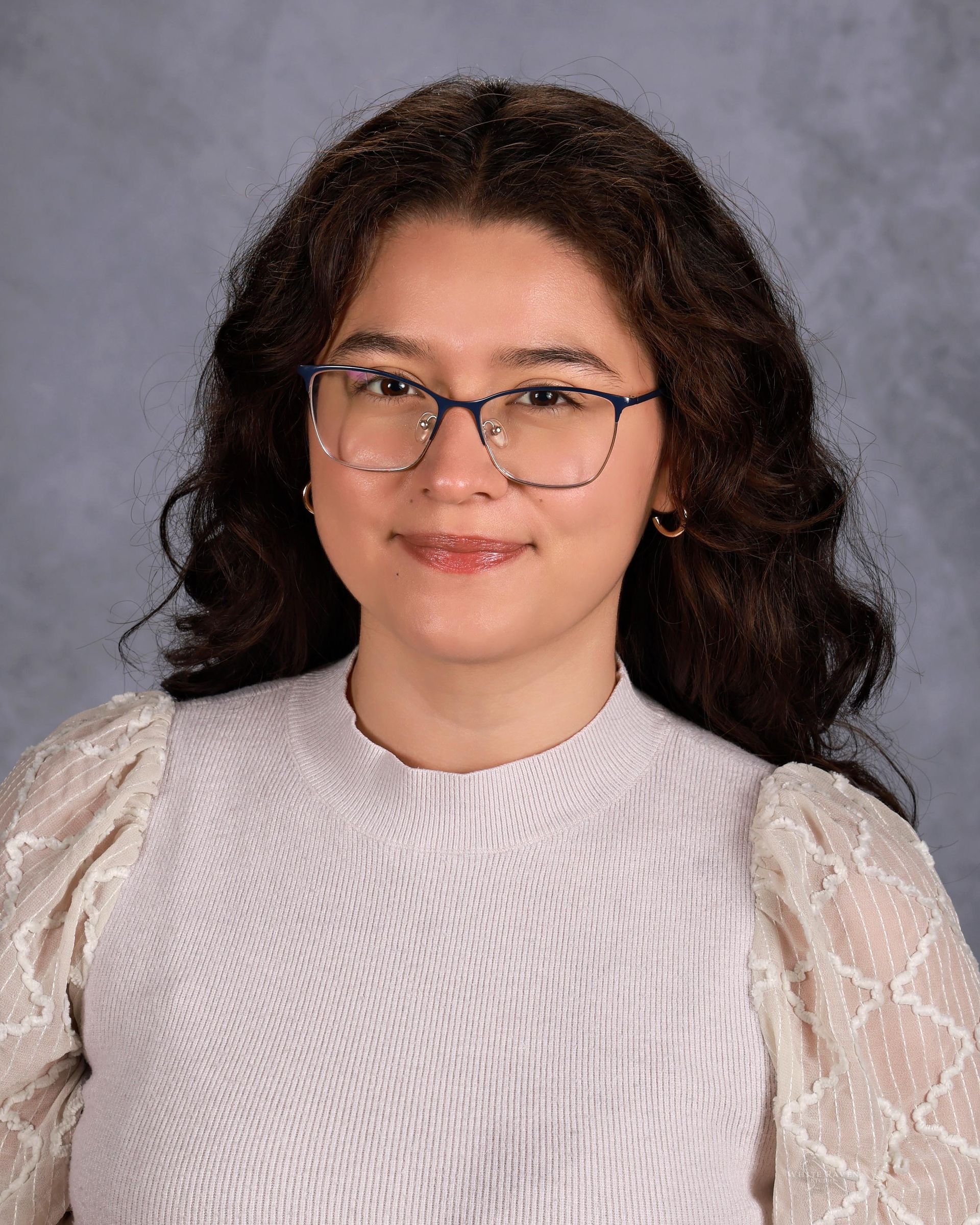 Woman smiling in front of gray backdrop