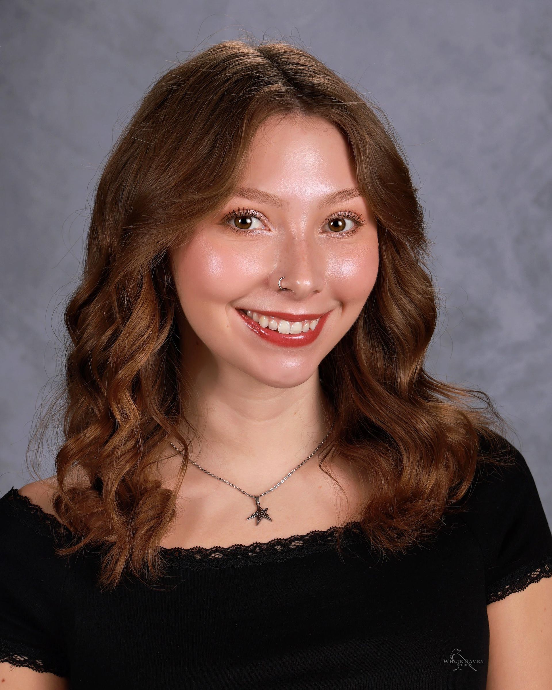 Woman smiling in front of gray backdrop