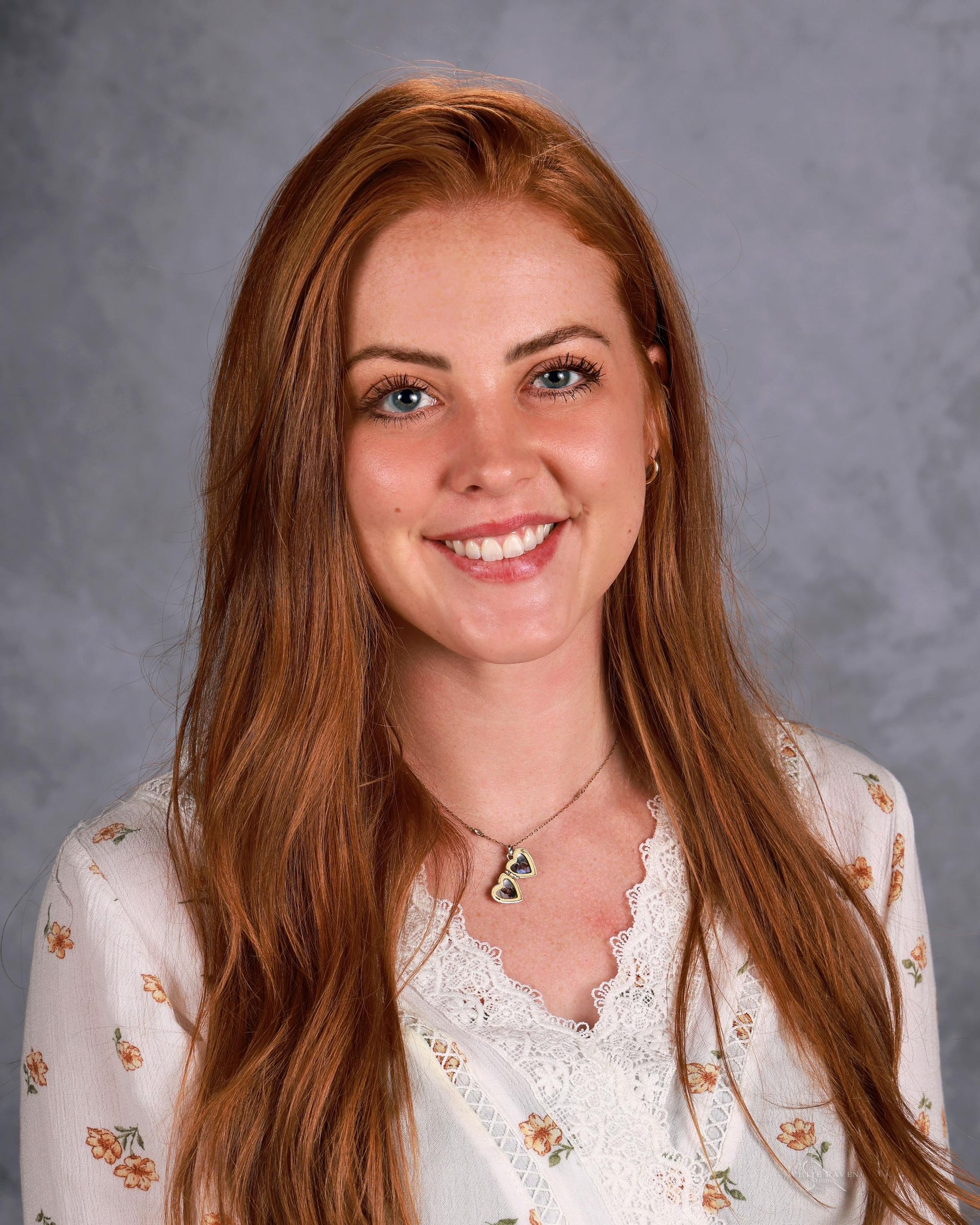 Woman smiling in front of gray backdrop
