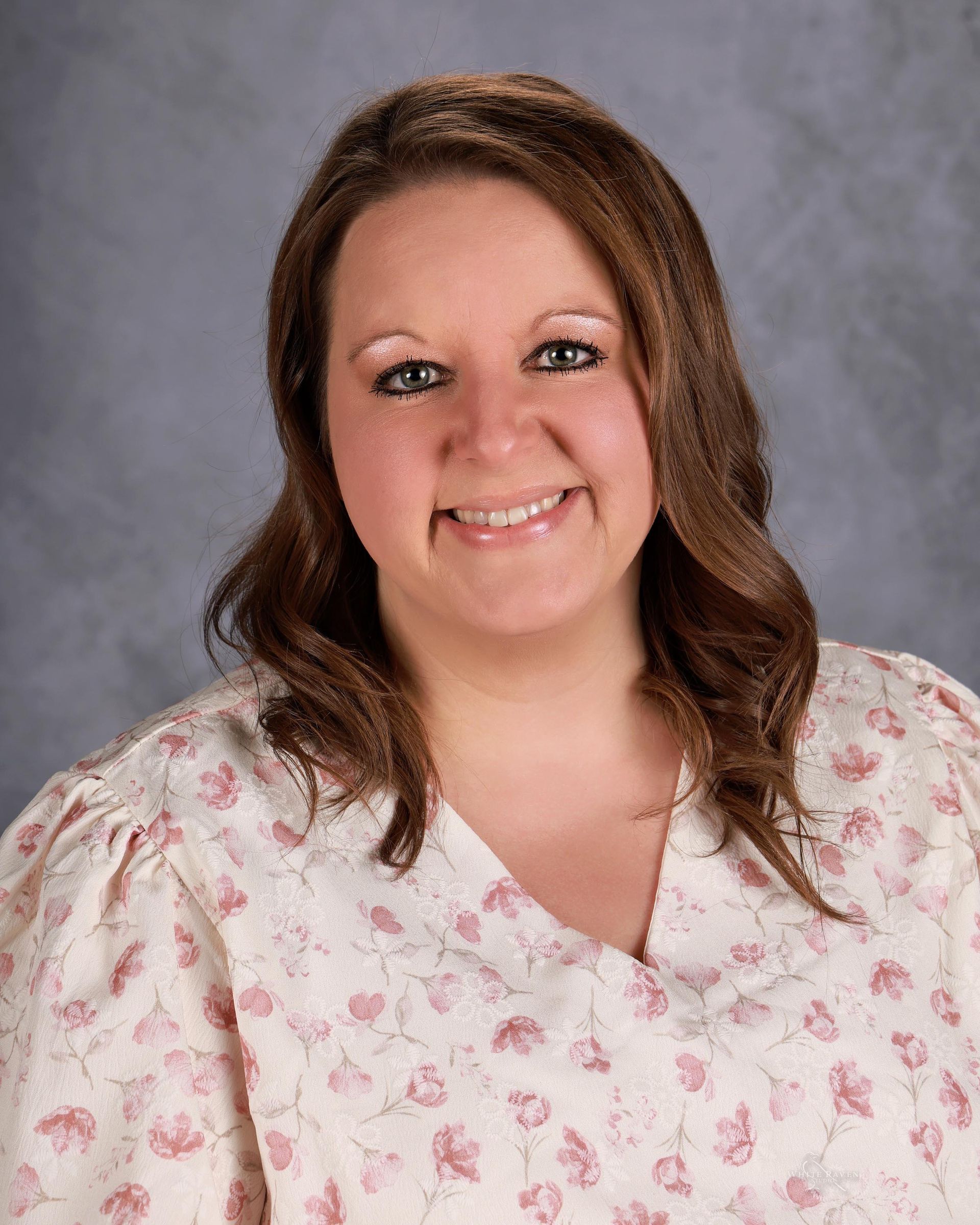 Woman smiling in front of gray backdrop