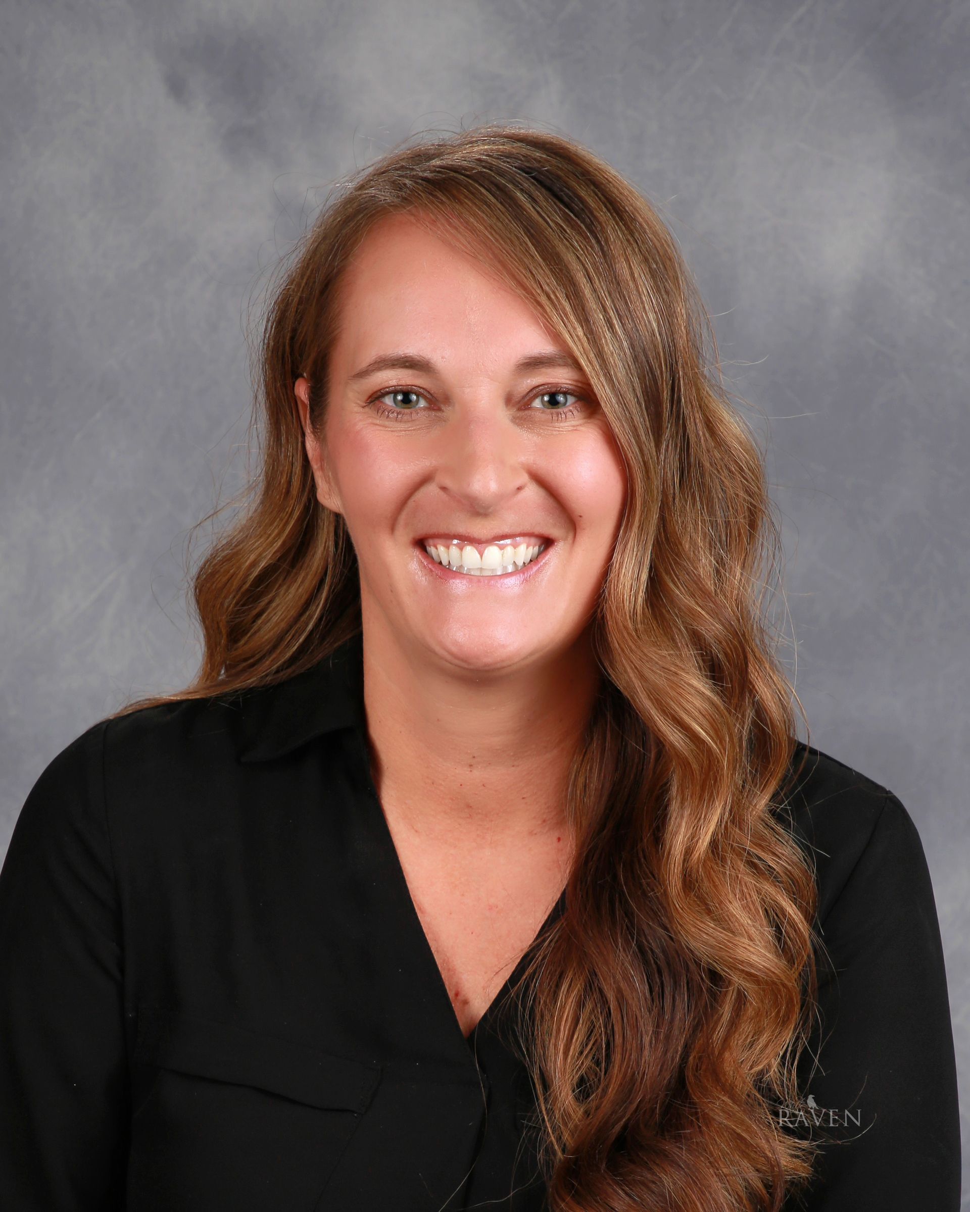 Woman smiling in front of gray backdrop