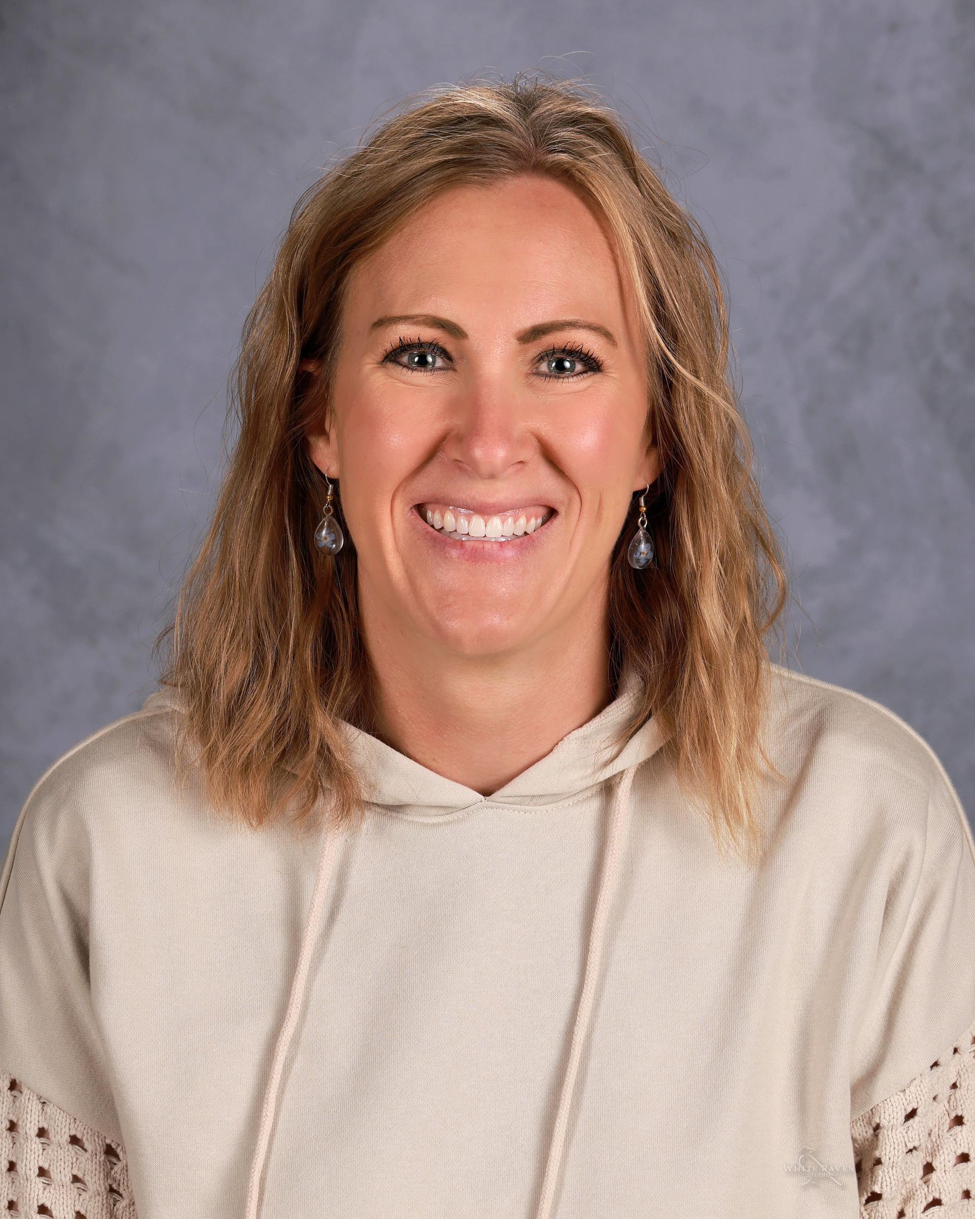 Woman smiling in front of gray backdrop