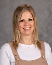 Woman smiling in front of gray backdrop