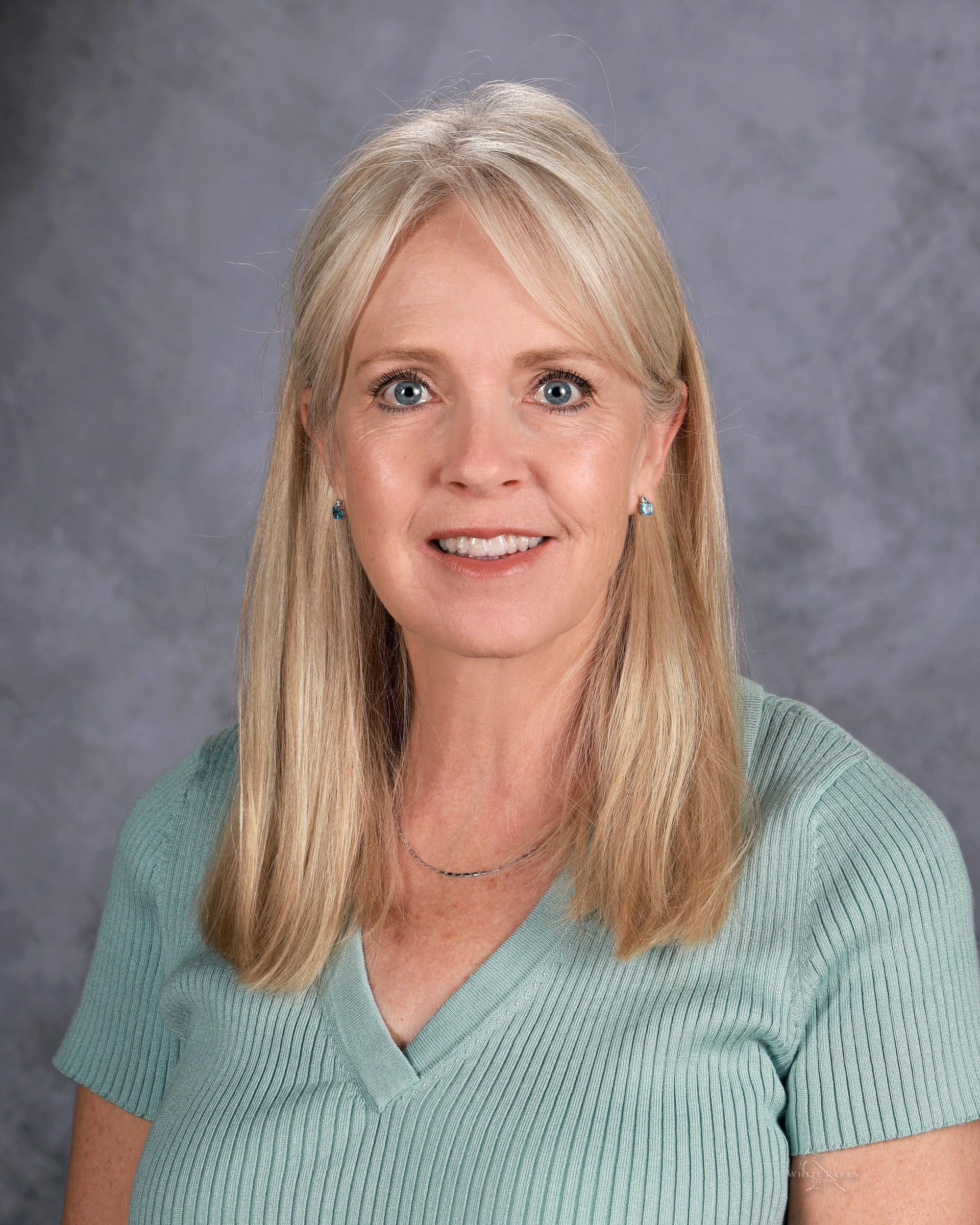 Woman smiling in front of gray backdrop