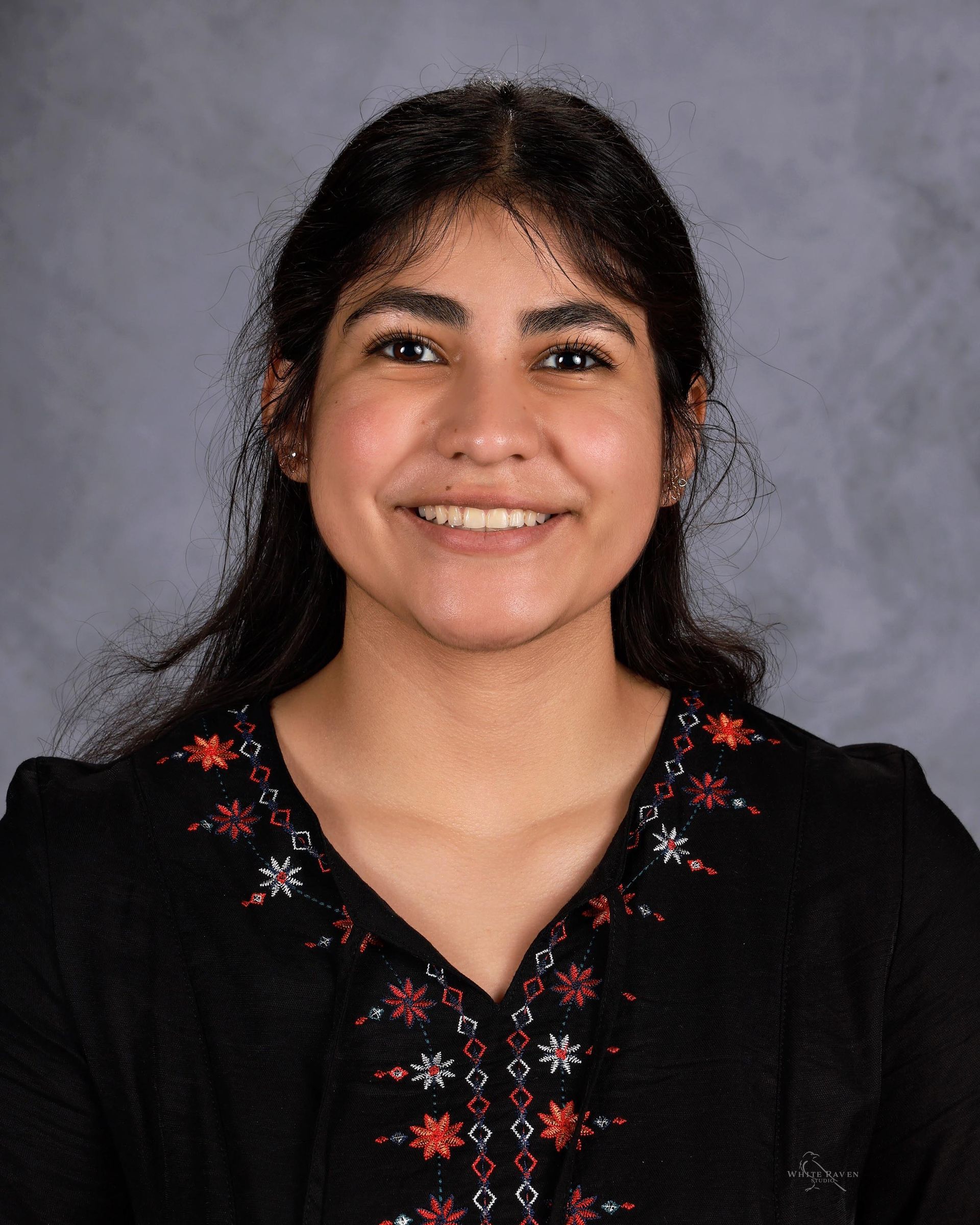 Woman smiling in front of gray backdrop
