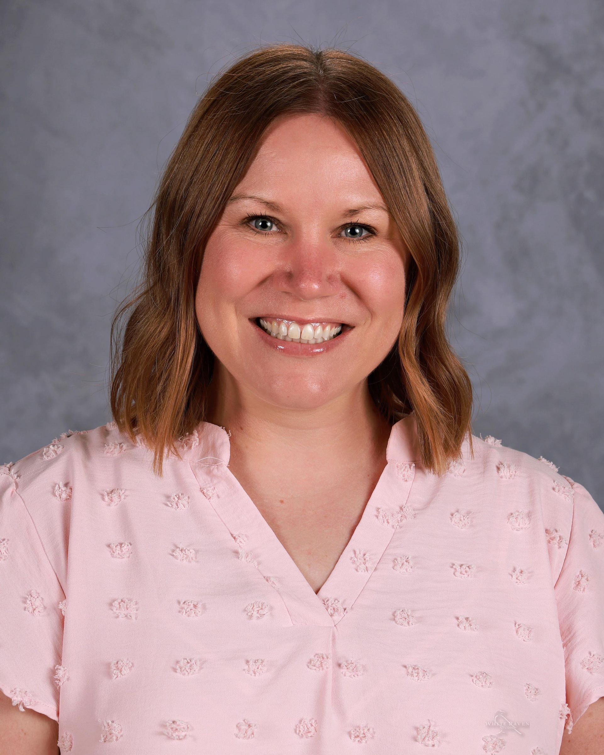 Woman smiling in front of gray backdrop