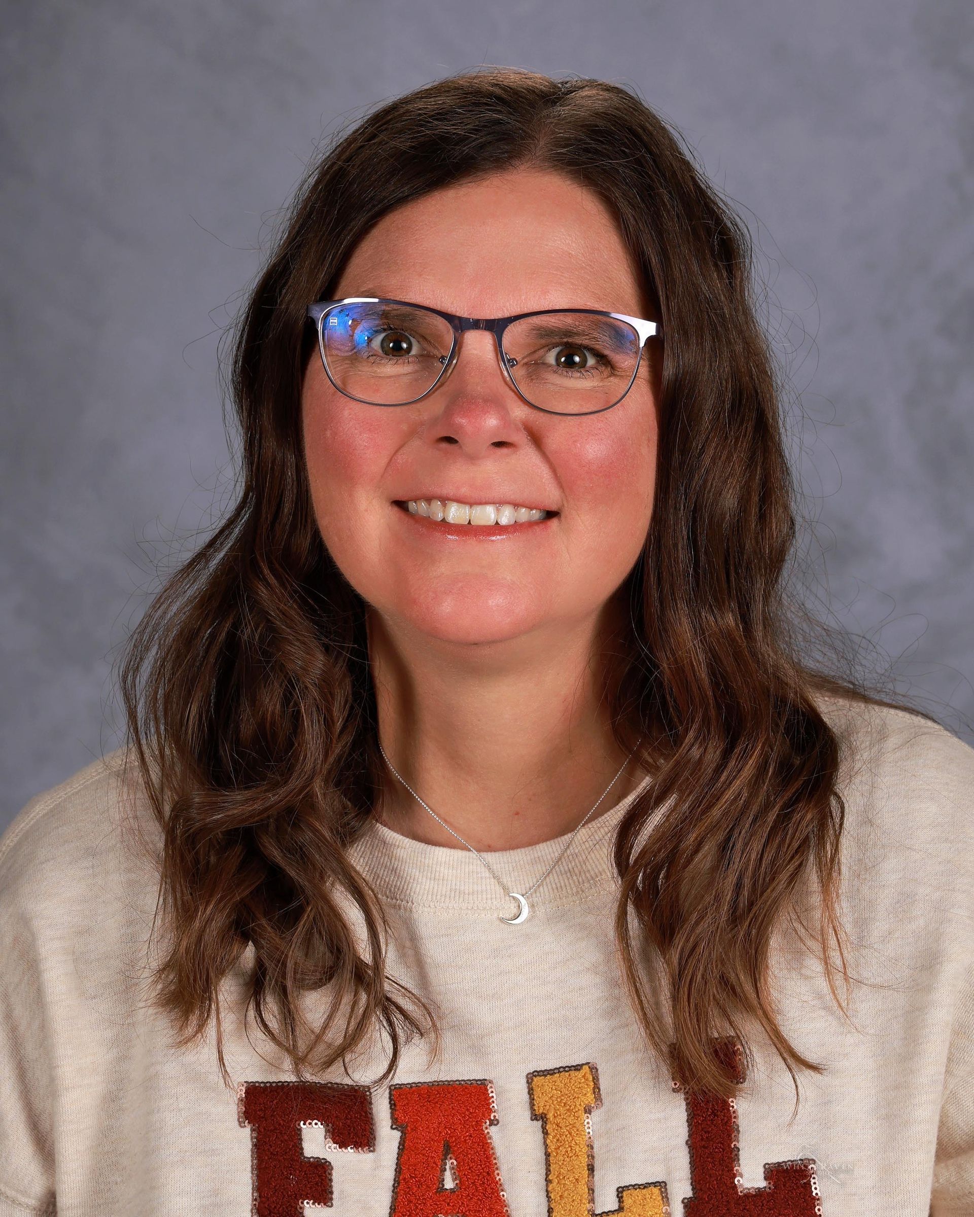 Woman smiling in front of gray backdrop
