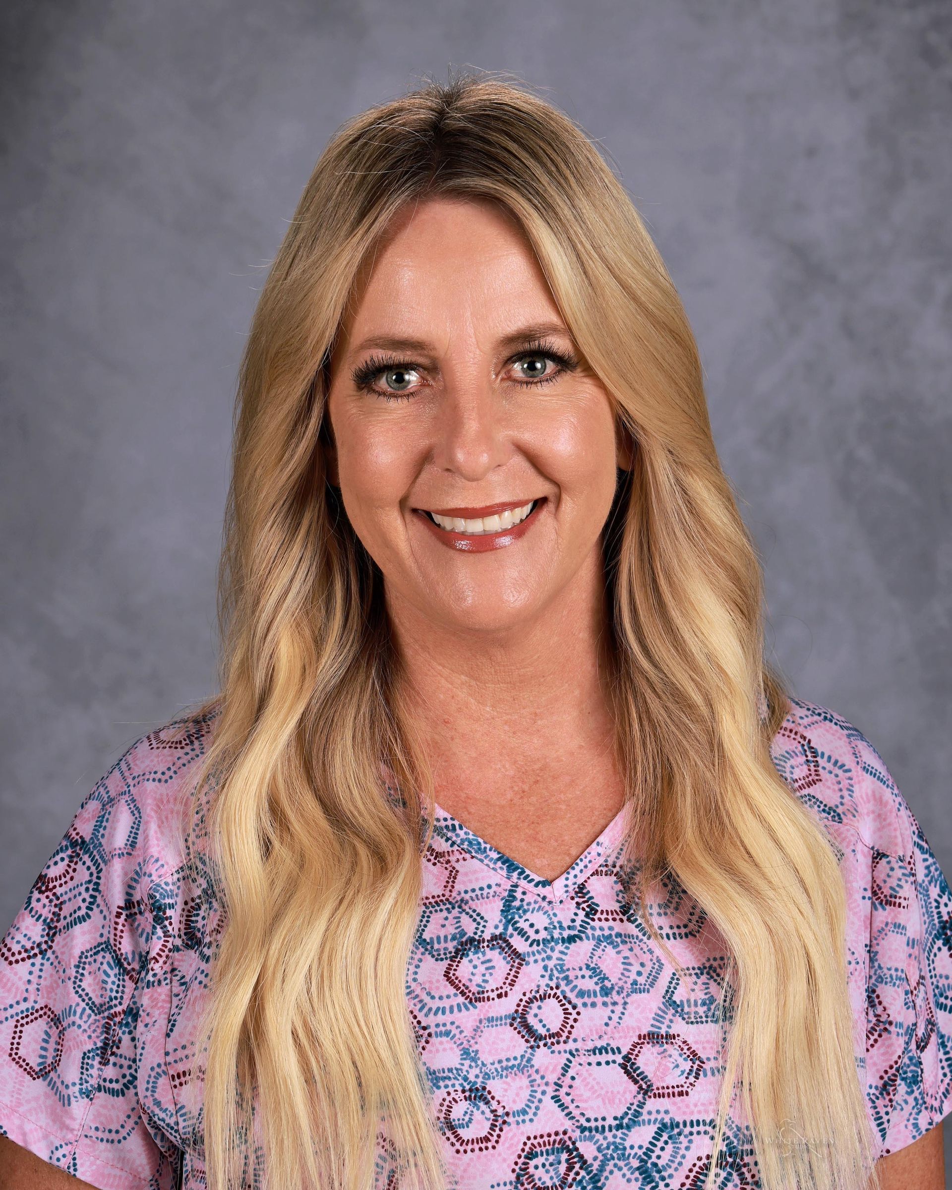 Woman smiling in front of gray backdrop