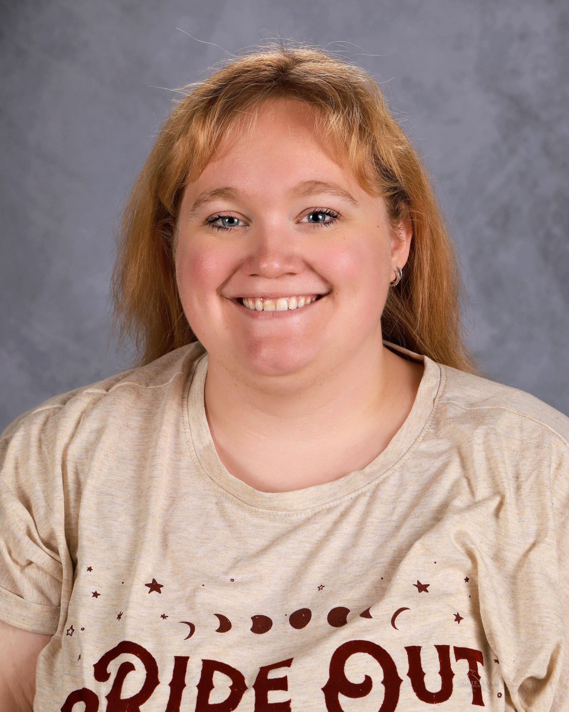 Woman smiling in front of gray backdrop