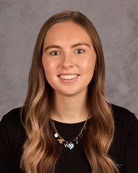 Woman smiling in front of gray backdrop