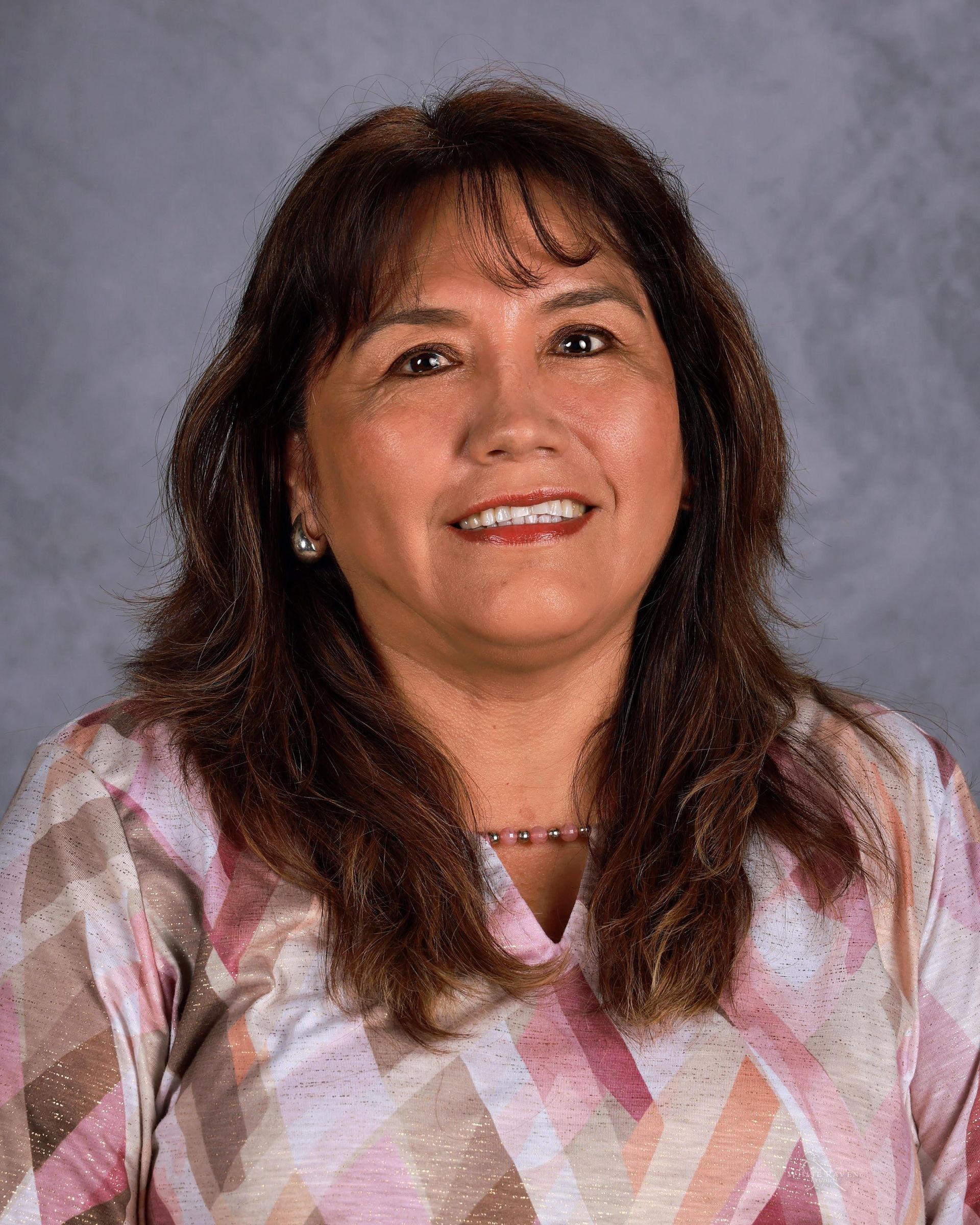 Woman smiling in front of gray backdrop