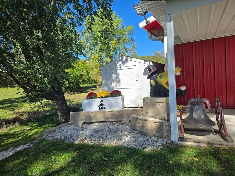 Barn, flower boxes, a bell outdoors, on a sunny day at the Clarke County Historical Museum in Osceola, IA.