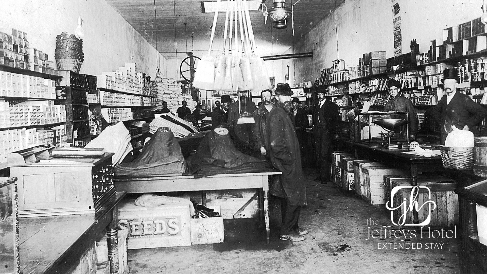 Interior of a store, shelves stocked with goods, customers and staff interacting.