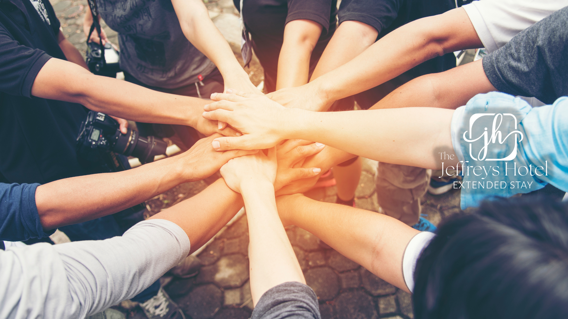 Hands stacked together in a team huddle, symbolizing unity and collaboration.