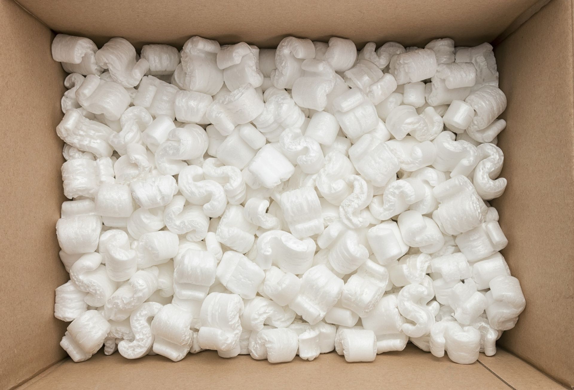 Cardboard box filled with white packing peanuts.