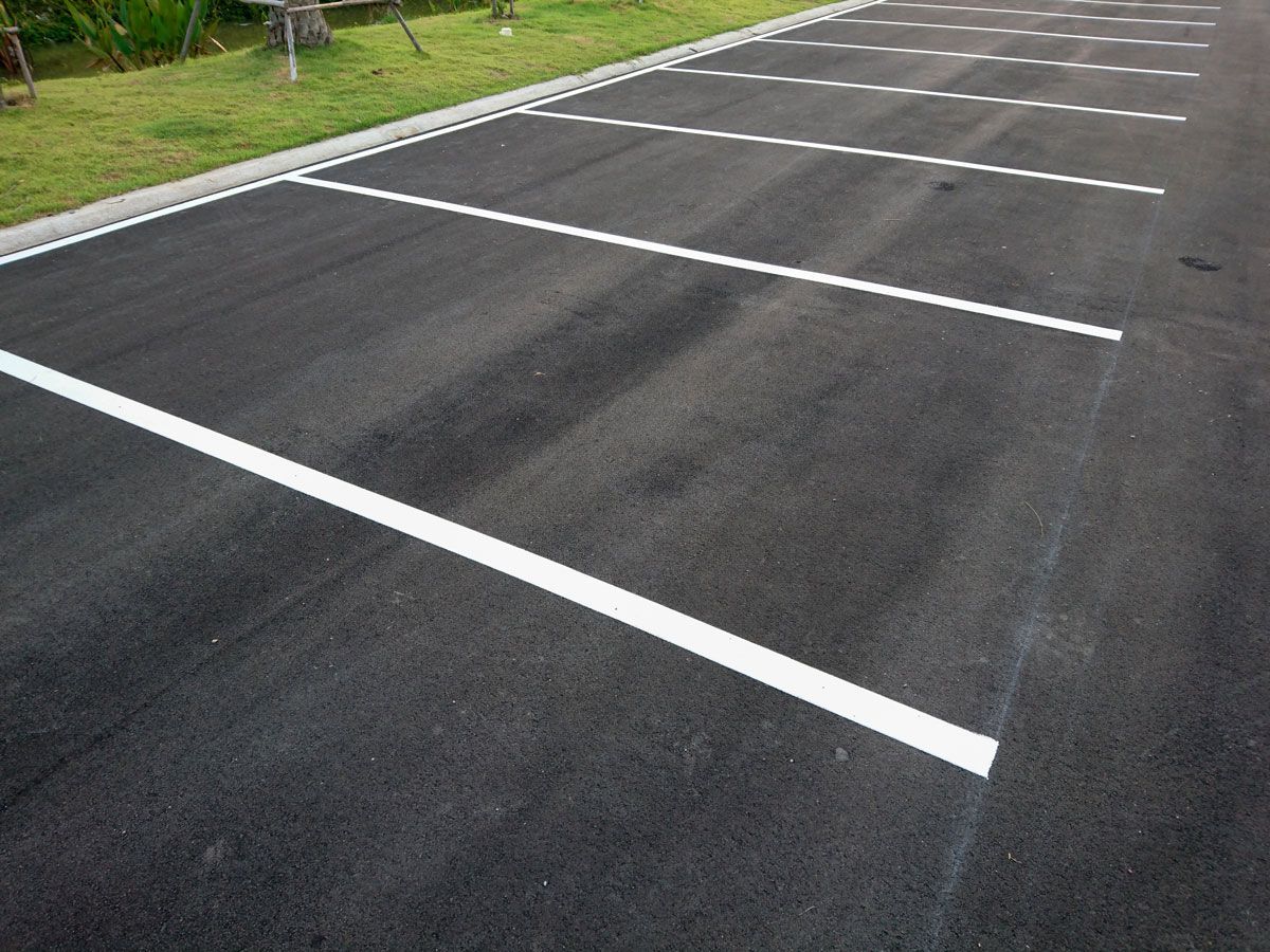 Asphalt parking spaces with white painted lines.