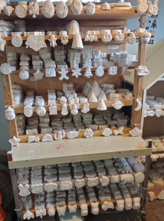 Shelves packed with white crocheted ornaments and small handmade craft items in a shop display