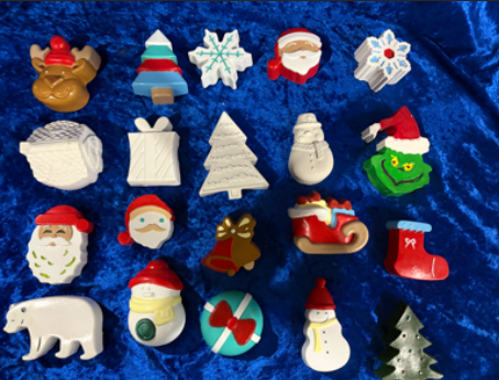 Assorted Christmas-themed ornaments and figurines arranged on a blue velvet background