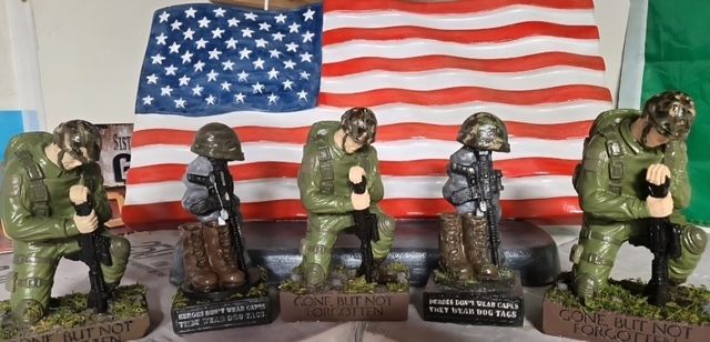 Soldiers figurines before a U.S. flag backdrop, in green and dark uniforms