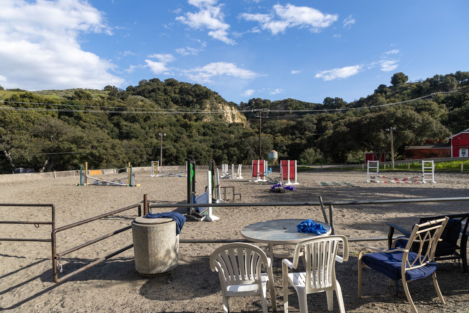 There is a table and chairs in the middle of a dirt field.