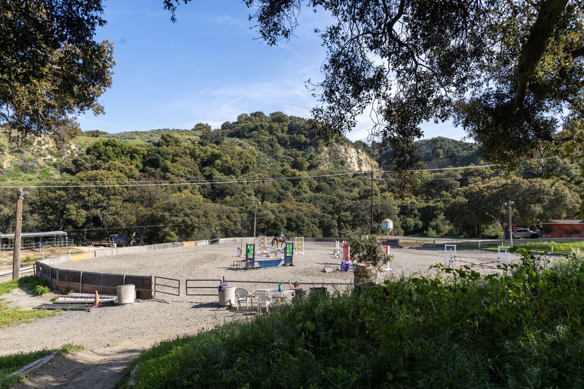 A fenced in area with trees and mountains in the background