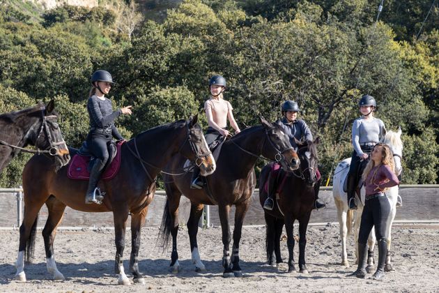A group of people are standing next to each other on horses.