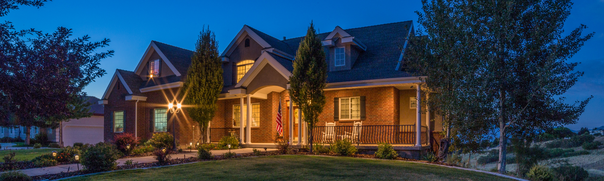 Cozy suburban home at night with glowing lights, symbolizing safety & protection with home insurance
