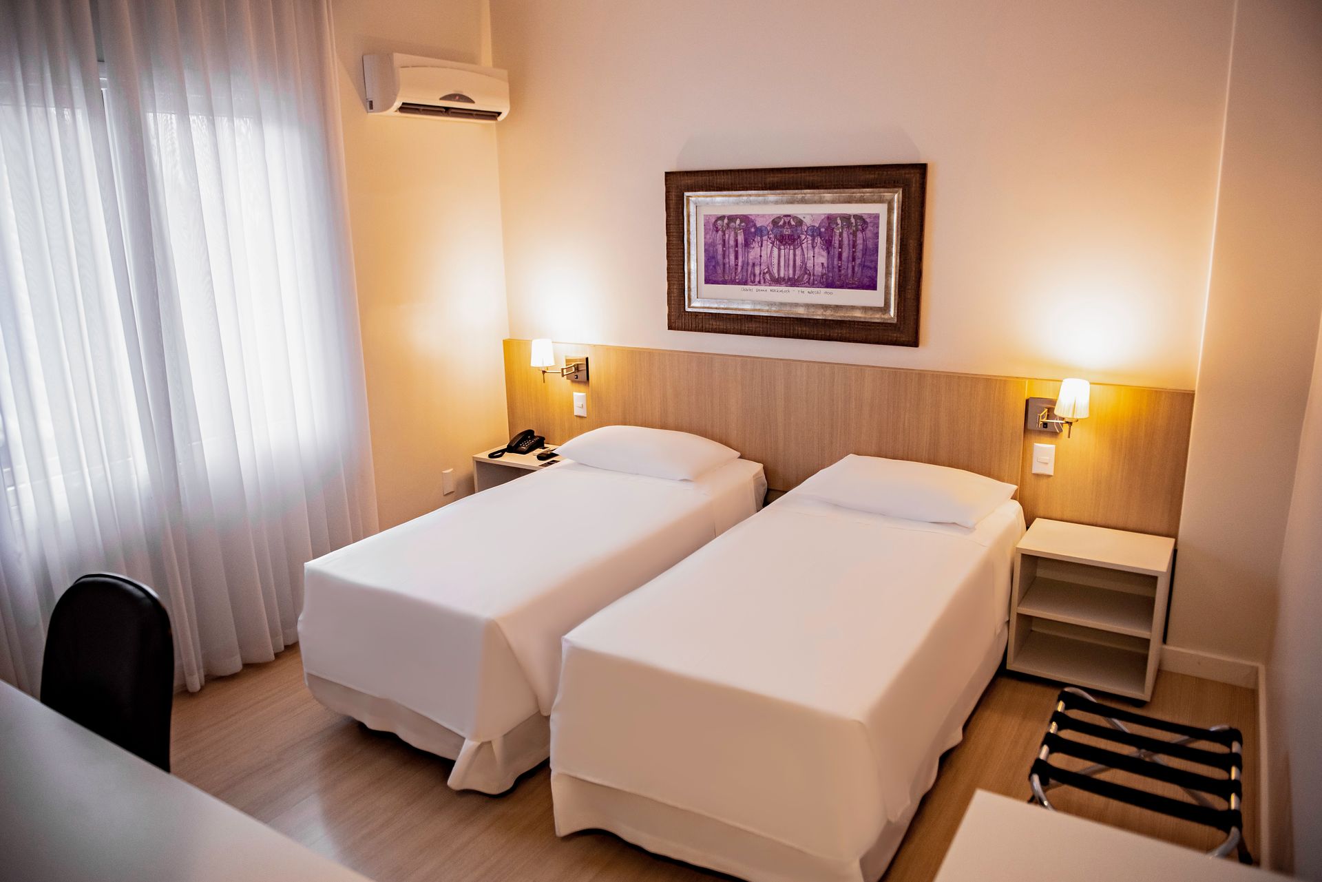 A hotel room with two twin beds and a desk.