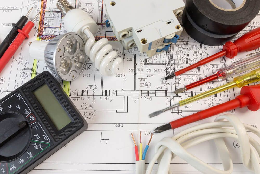 A Bunch of Electrical Tools are Laying on Top of a Blueprint — DMC Electrical & Air Cooling Pty Ltd in Ayr, QLD