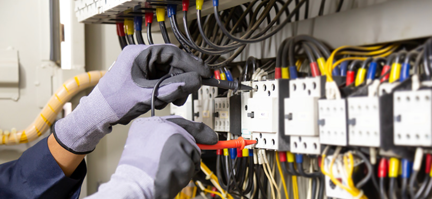A Person is Working on an Electrical Panel with a Screwdriver - DMC Electrical & Air Cooling Pty Ltd in Ayr, QLD