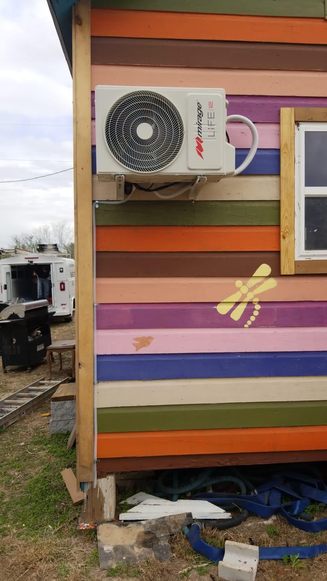 A colorful house with a fan on the side of it.