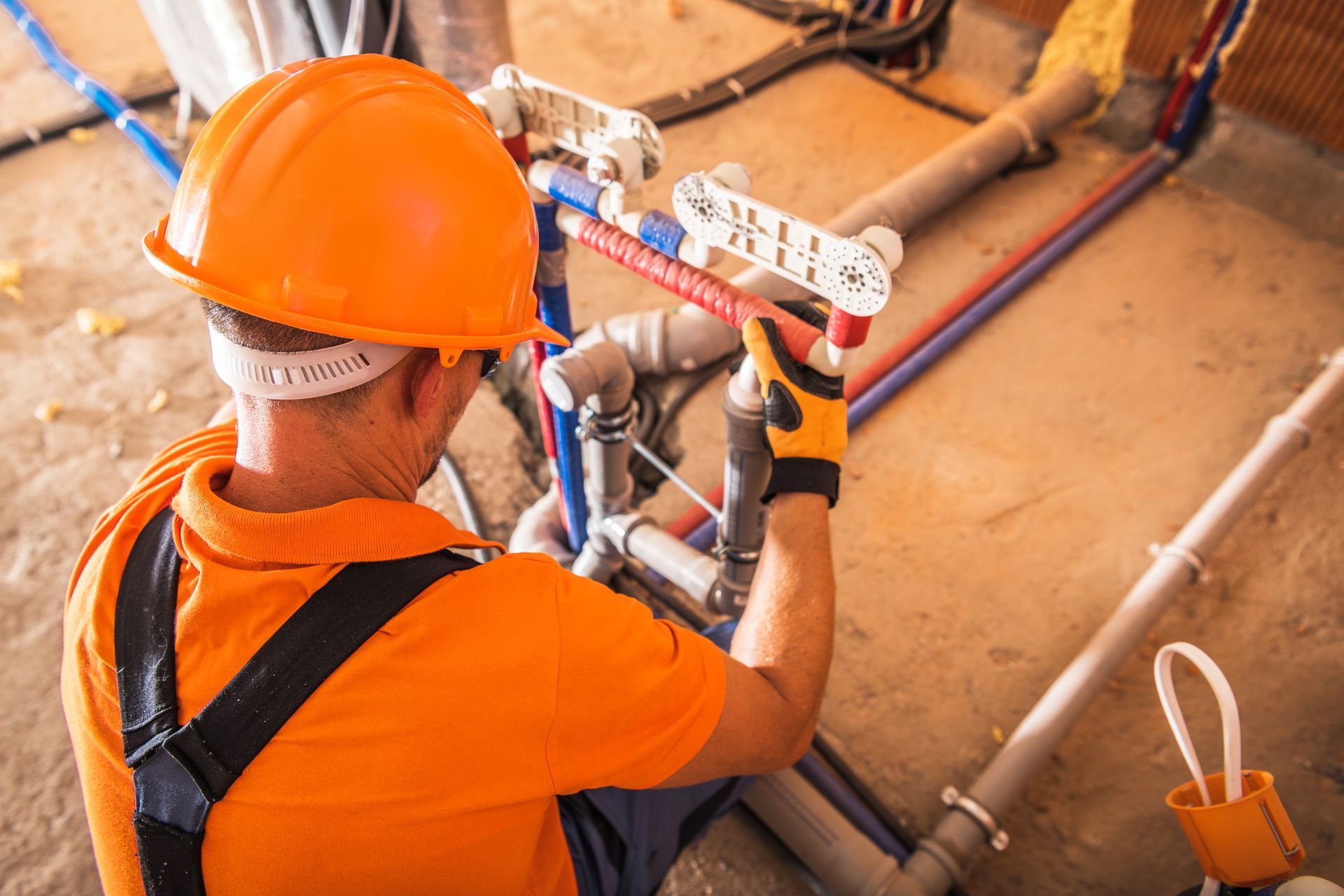 Worker installing pipes on a commercial plumbing system. Worker installing pipes on a commercial plumbing system.