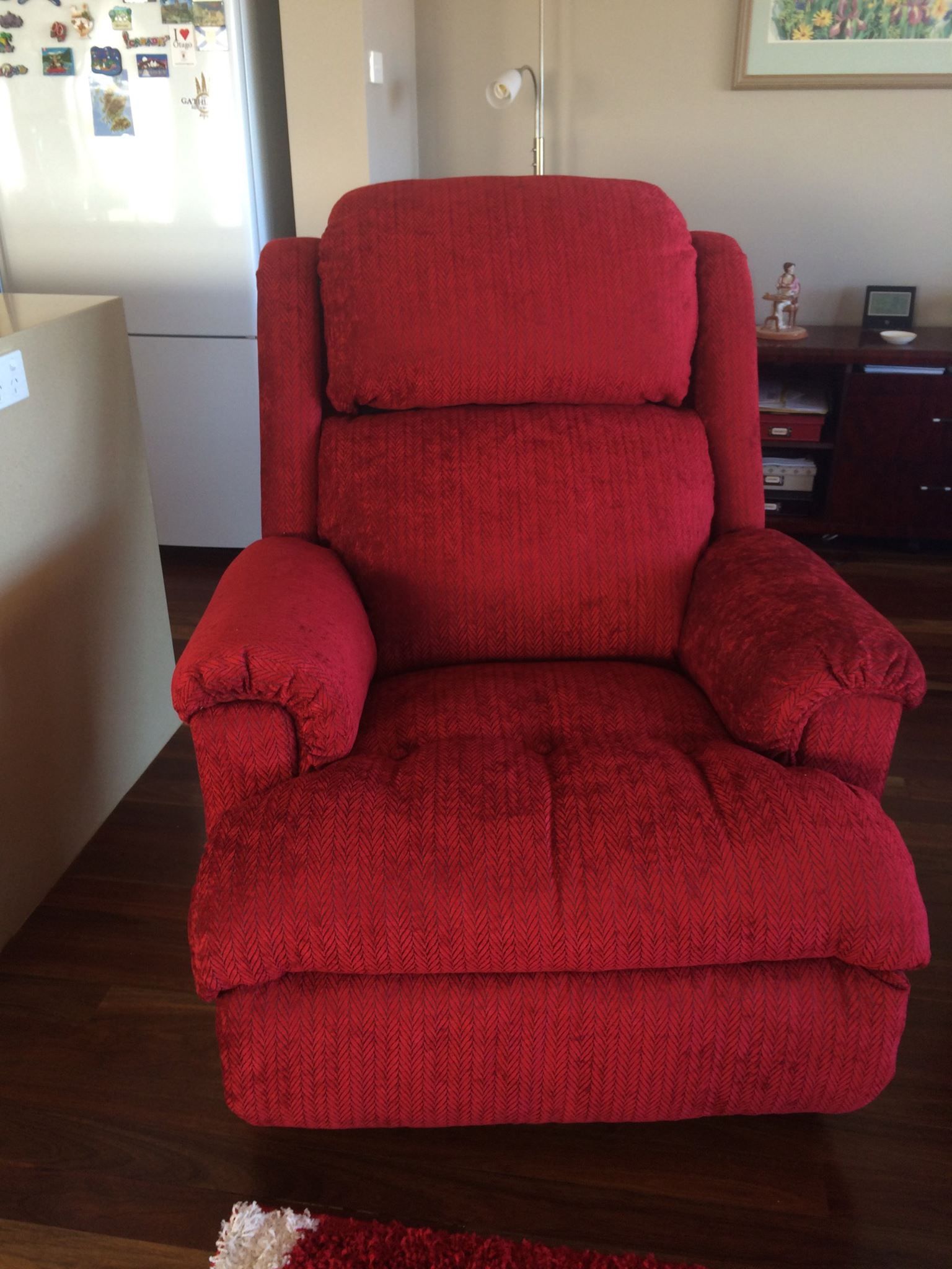 A Red Recliner Is Sitting on A Wooden Floor in A Living Room — Metreson Upholstery In Shellharbour, NSW