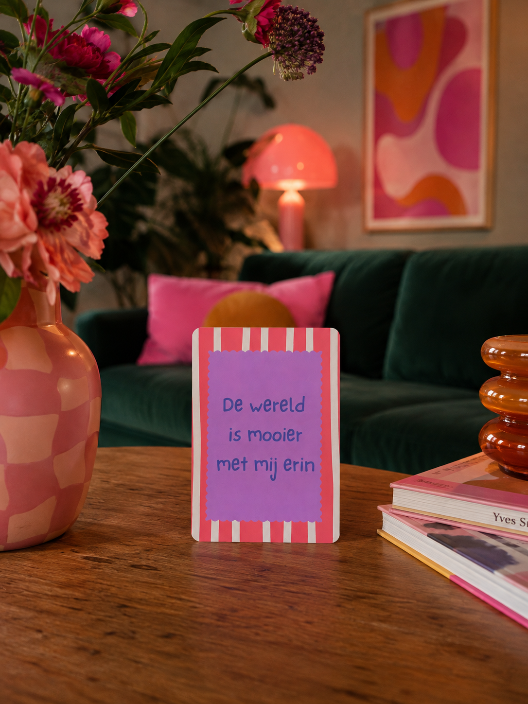 Kleurrijke affirmatiekaarten op een houten tafel in een gezellige woonkamer met een donkergroene bank en een roze lamp.