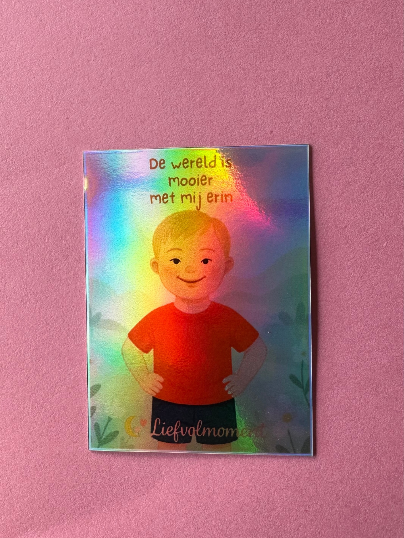 Vier holografische rechthoekige stickers, elk met een afbeelding van een ander persoon, geplakt op een roze ondergrond.