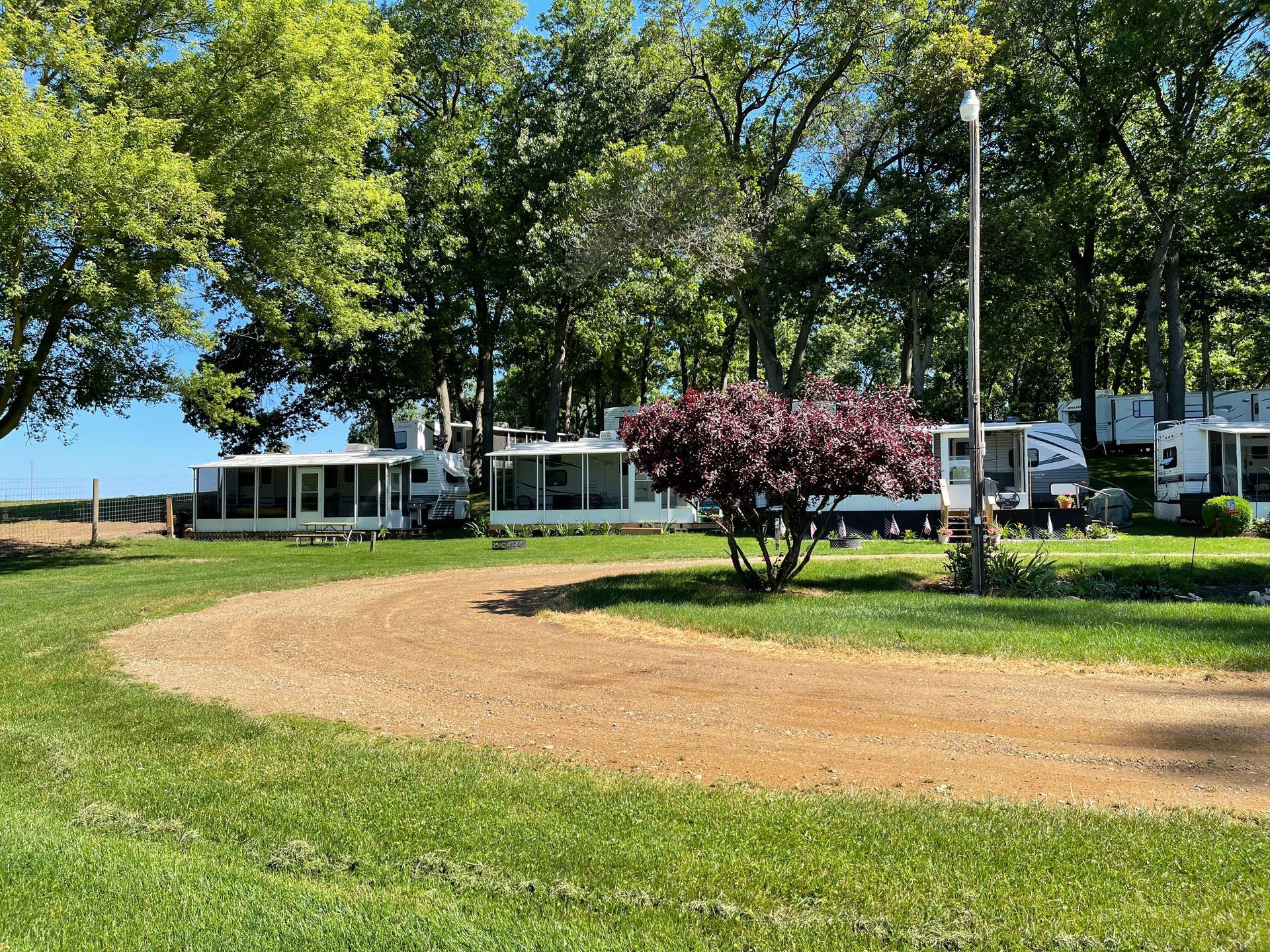 A rv parked in a grassy field with trees in the background.