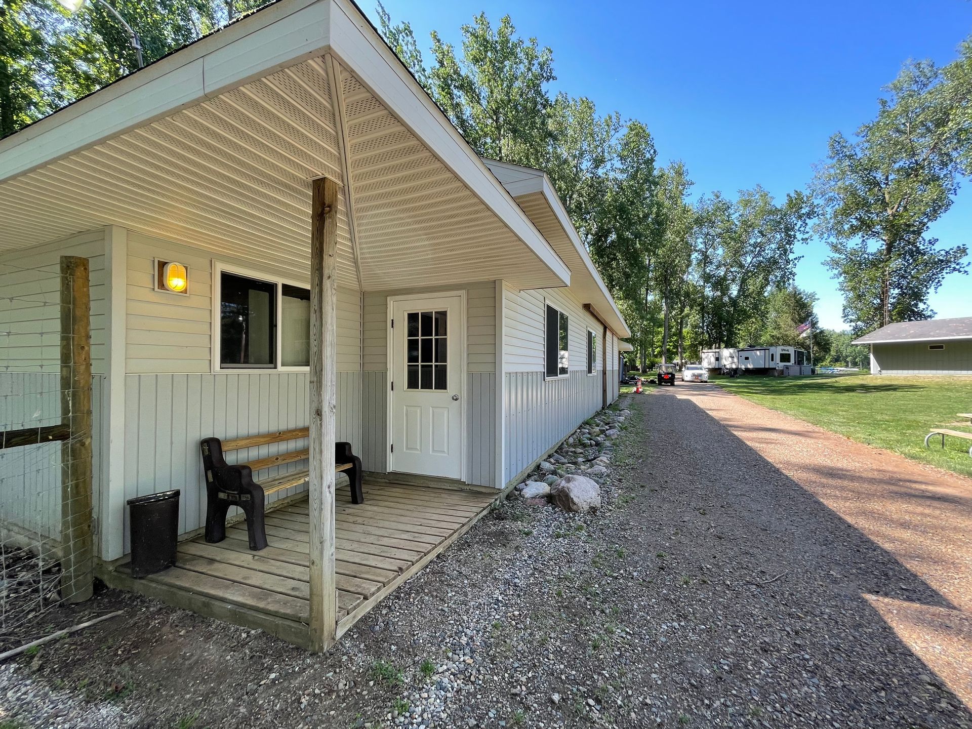 A small white house with a porch and a bench