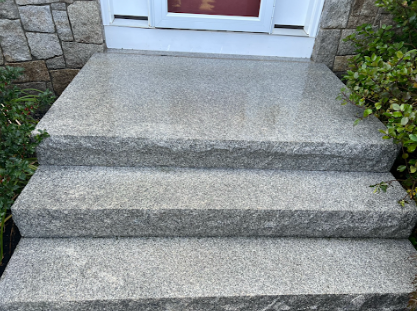 A set of granite steps leading up to a door.