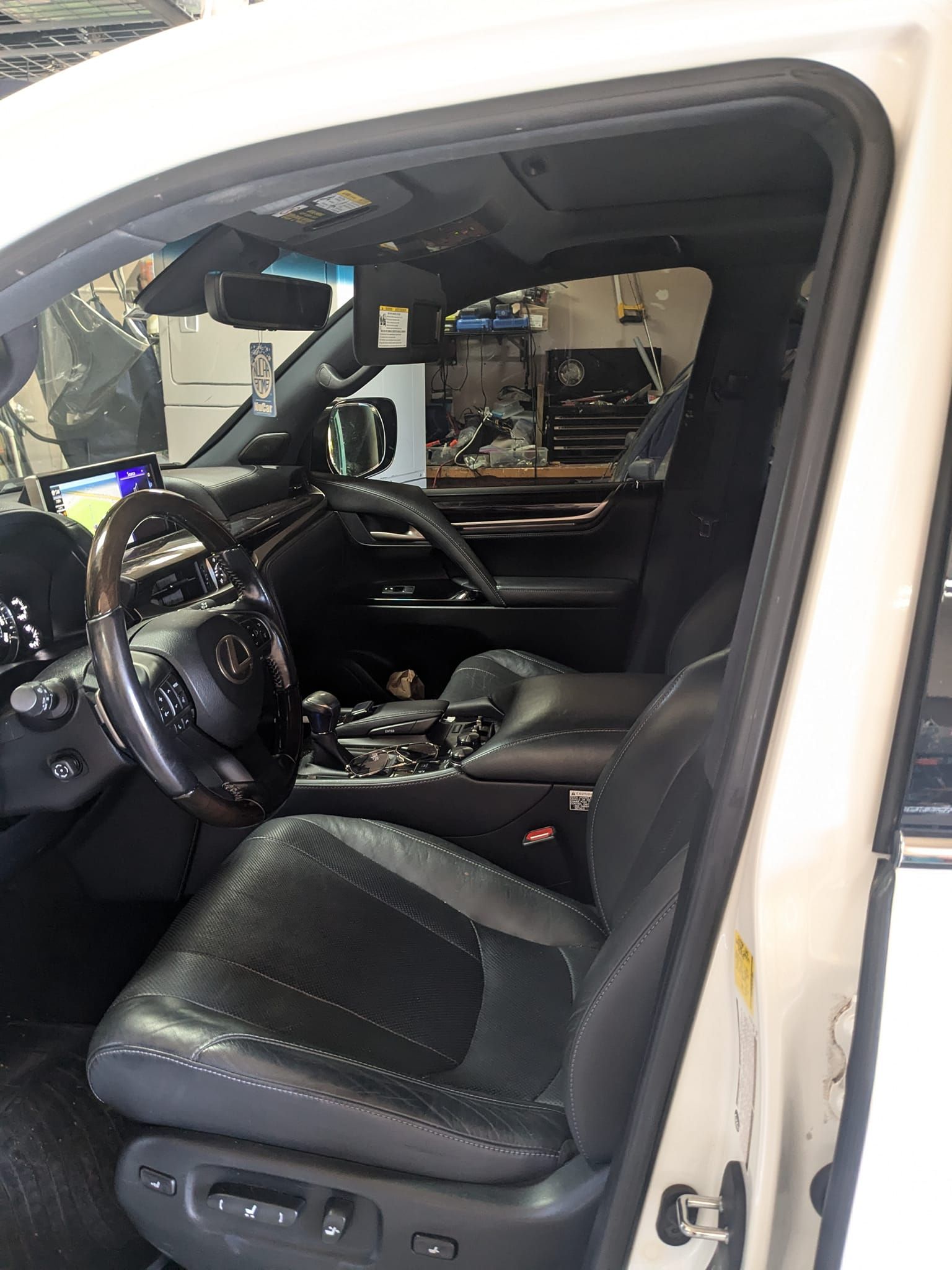 The interior of a white car with black seats and a steering wheel.