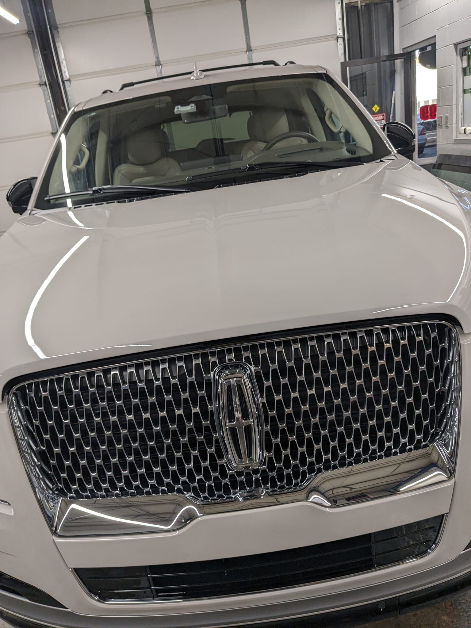 A white lincoln continental is parked in a garage.