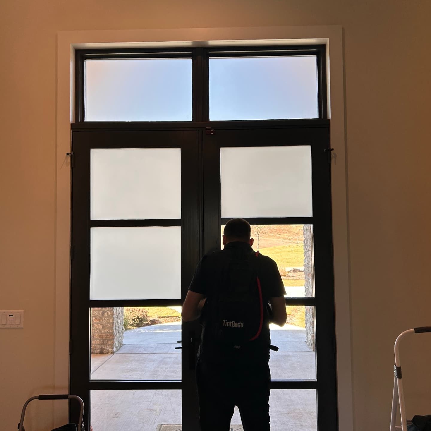A man with a backpack is standing in front of a door