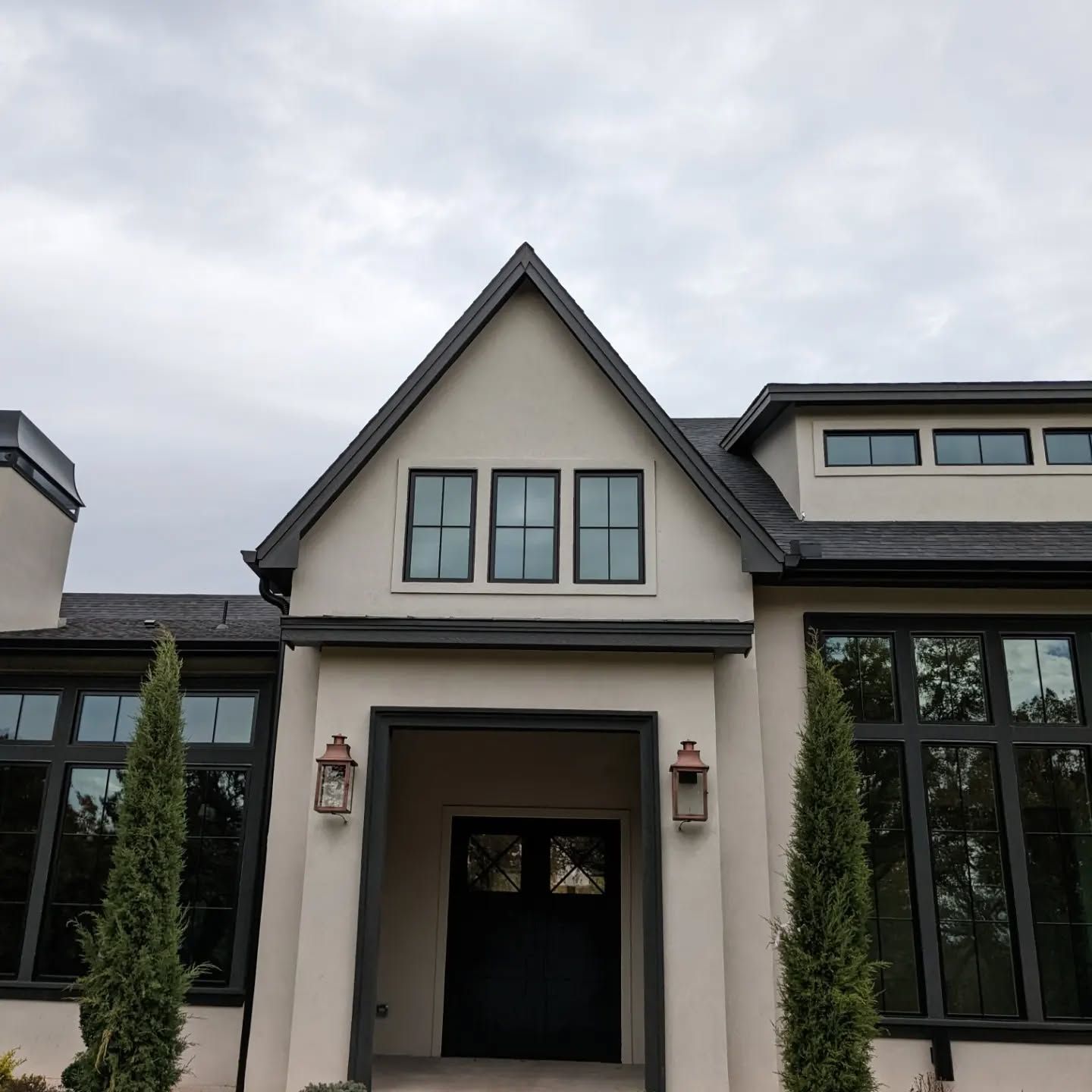A white house with a black roof and a black door