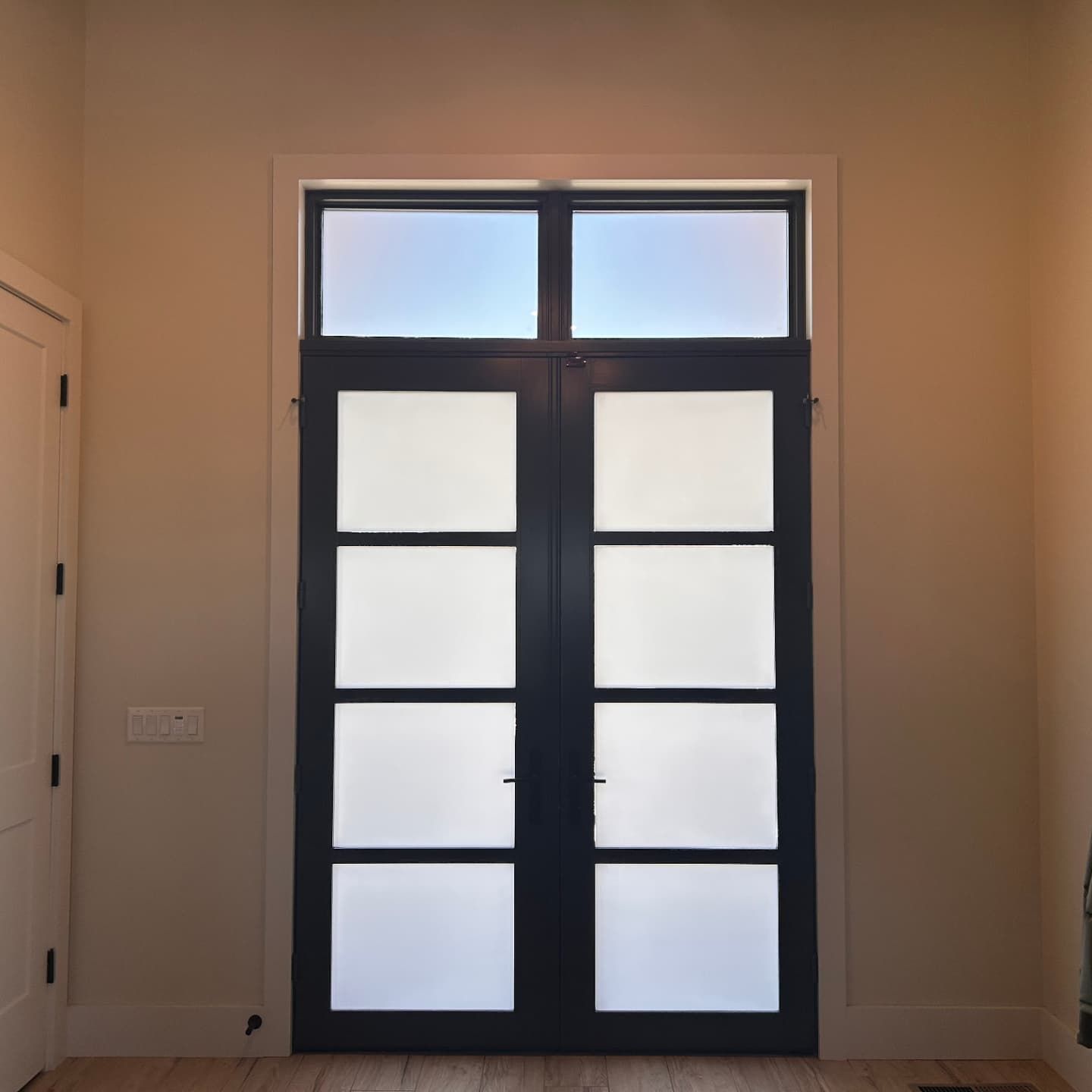 A door with a window above it in a room